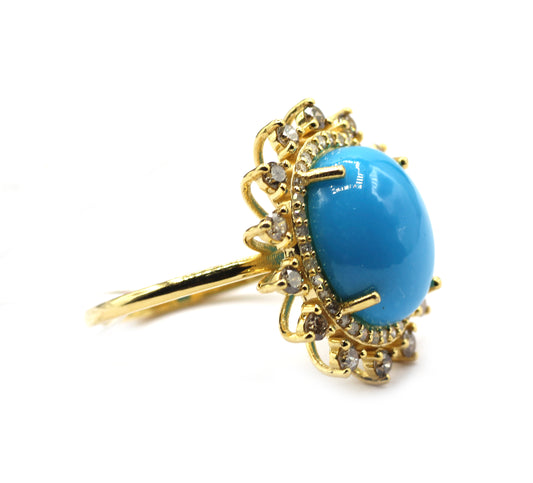 Gold ring with a blue gemstone on a white background