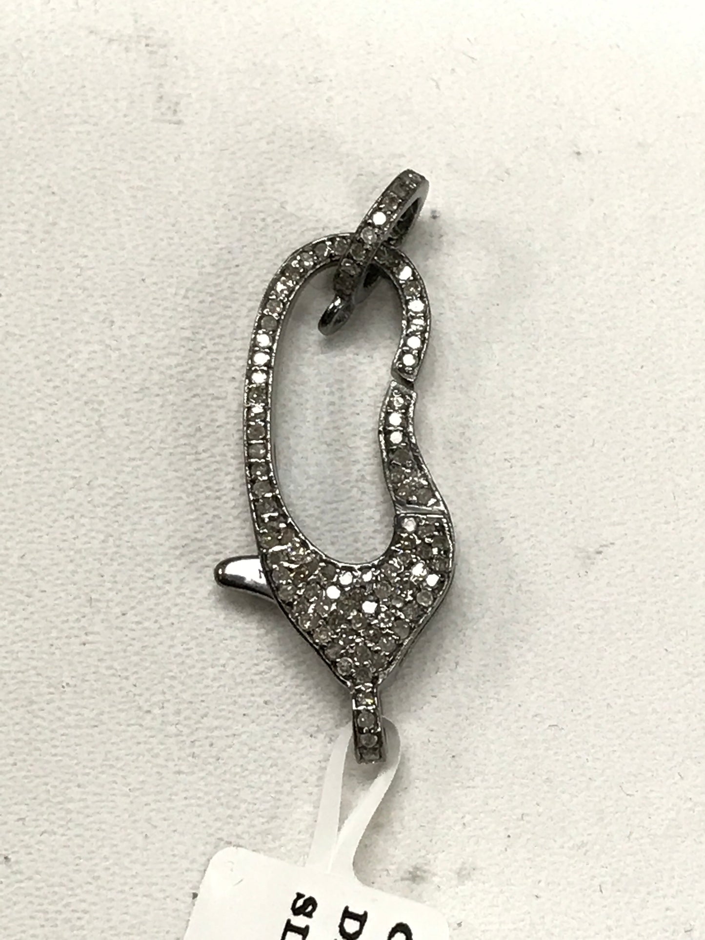 A diamond-encrusted clasp with a pave pattern, attached to a tag with the text 'D-SILVER'.